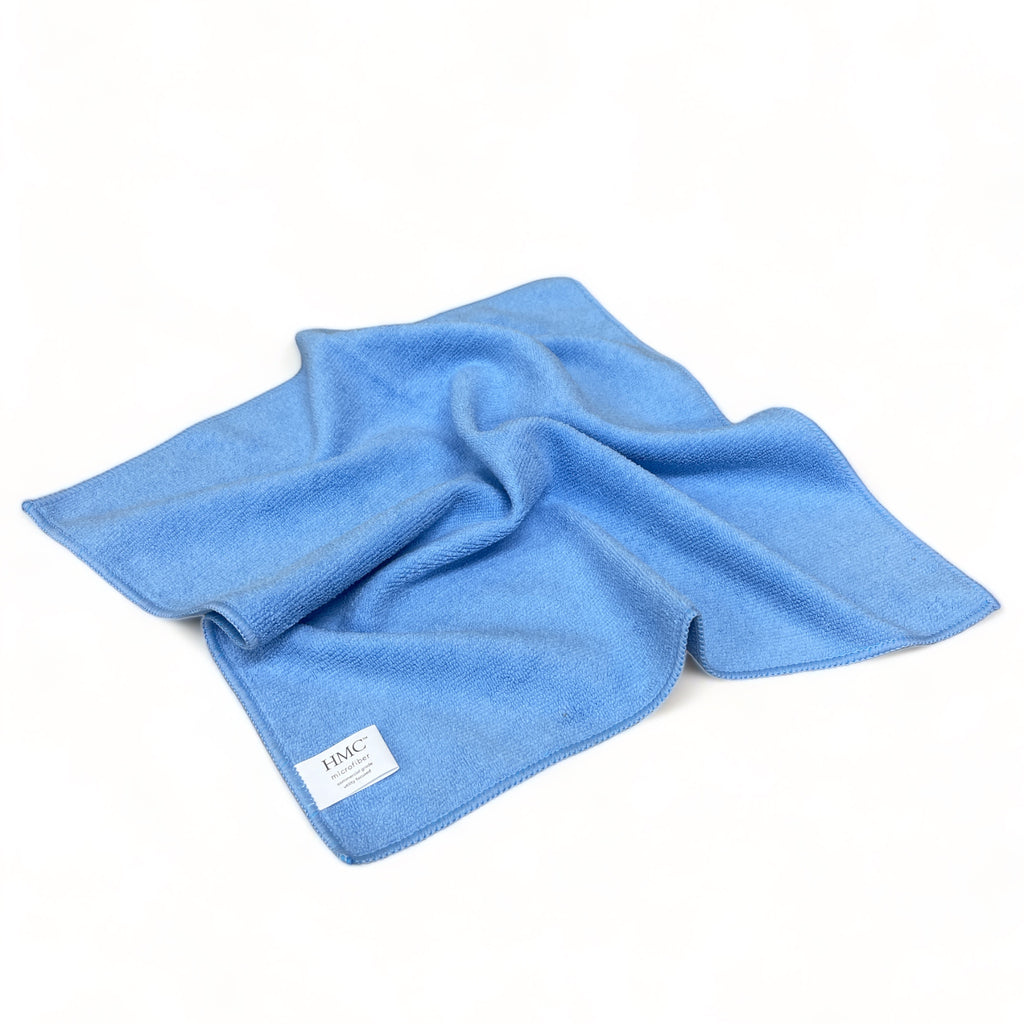 Single blue microfiber towel laid flat on a white surface